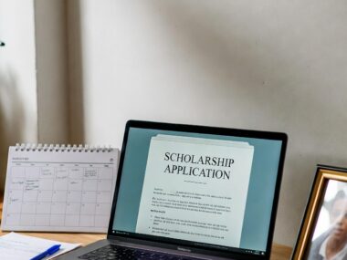 Student preparing scholarship applications on laptop with calendar open for scholarship deadlines 2025–2026, organized workspace with notes and planner