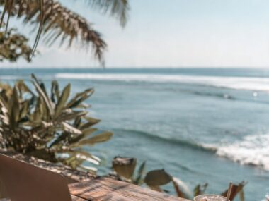 A laptop on a beachside workspace overlooking the ocean, representing the best remote jobs that can be done from anywhere.