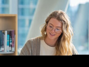 An international student studying in a modern library, representing smart financial planning and finances while studying abroad.